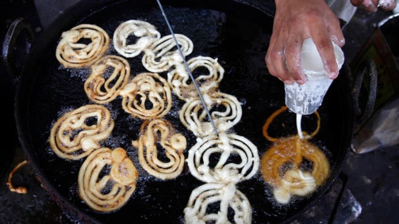 Jalebi (India): una masa que se pasa por un paño de muselina en el aceite y luego se sumerge en jarabe de azúcar para obtener una textura chiclosa y crujiente. Como muchos otros alimentos que cruzan las fronteras modernas, también es popular en otras partes de Asia. Crédito: Rahmat Gul/AP