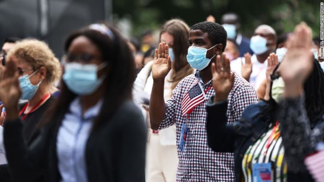 Un grupo de personas levanta la mano al prestar juramento de fidelidad durante una ceremonia de naturalización el 17 de septiembre de 2021, en la ciudad de Nueva York.