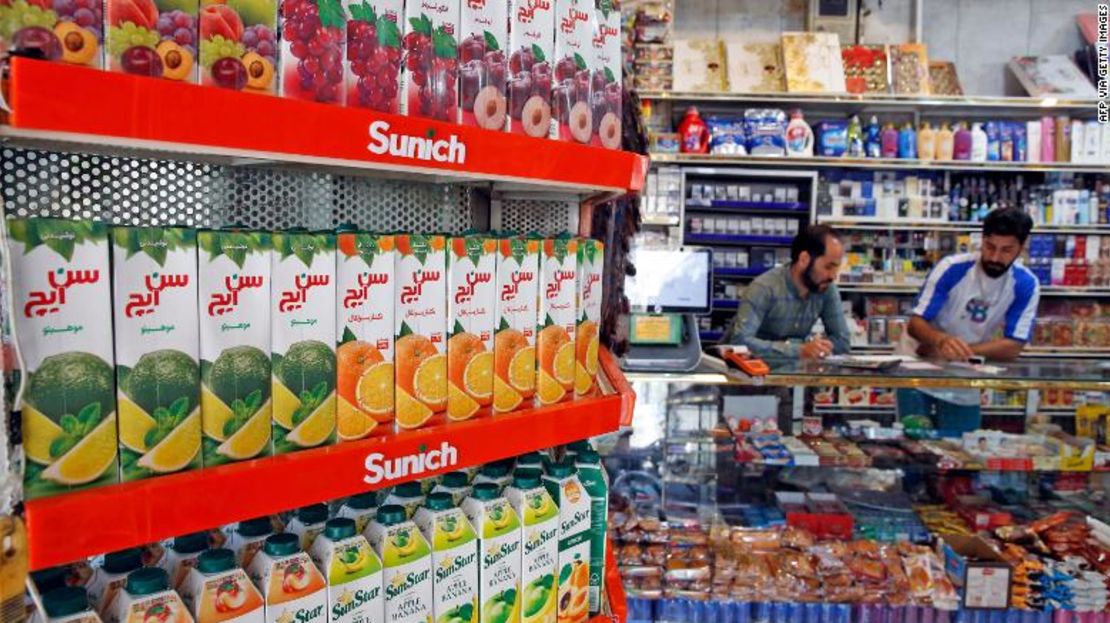 Los iraníes trabajan en una tienda de alimentos en la capital, Teherán, el 13 de mayo, mientras los precios de los productos básicos se disparan.