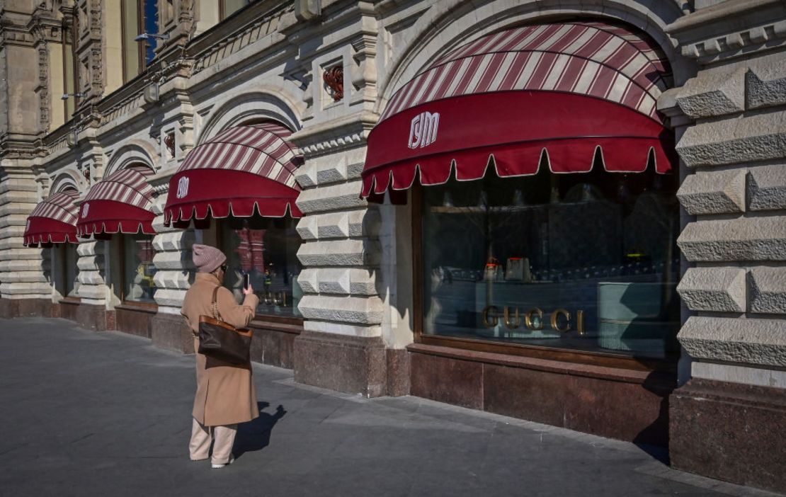 Una mujer toma fotos de los escaparates de la boutique de Gucci cerrada en los grandes almacenes GUM, en el centro de Moscú, el 16 de marzo de 2022.