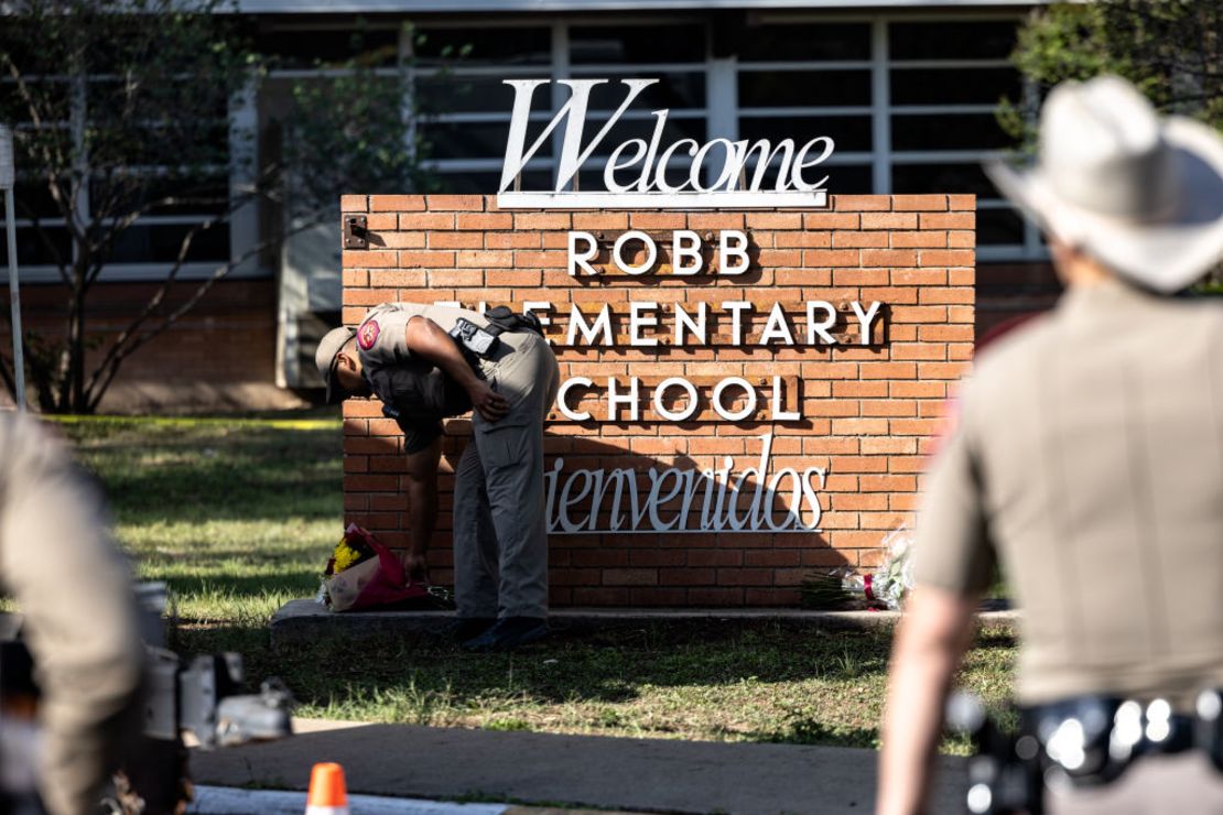 UVALDE, TX - 25 DE MAYO: Un policía estatal de Texas recibe flores para las víctimas de un tiroteo masivo ayer en la escuela primaria Robb, donde 21 personas fueron asesinadas, incluyendo 19 niños, el 25 de mayo de 2022 en Uvalde, Texas. El atacante, identificado como Salvador Ramos, de 18 años, habría sido abatido por las fuerzas del orden.