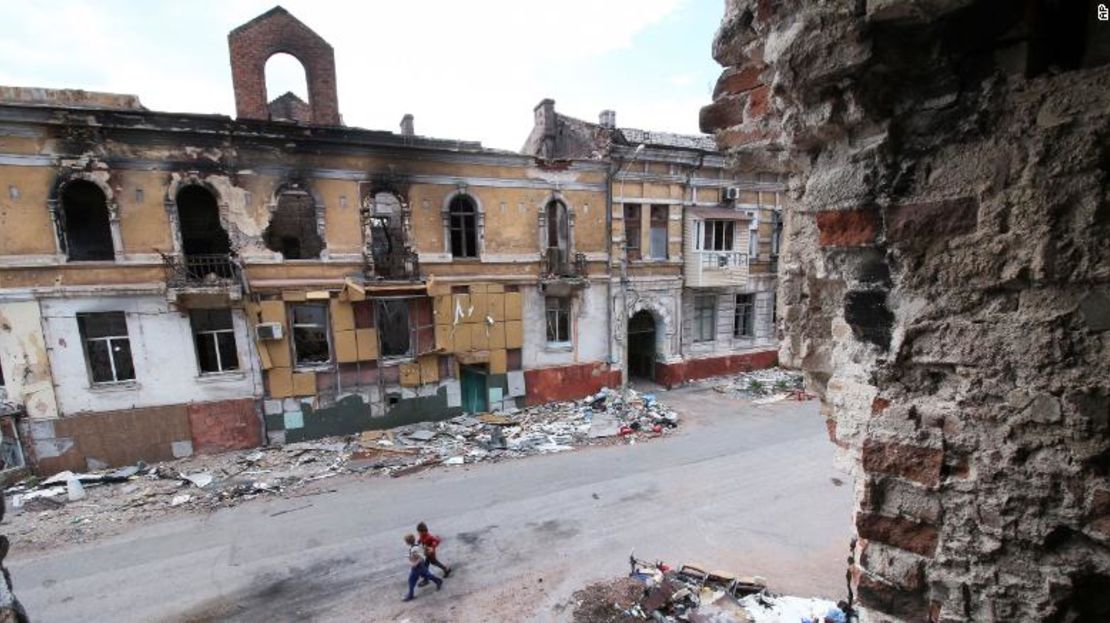 Niños caminan entre edificios destruidos durante los combates en Mariúpol, en el territorio bajo el gobierno de la República Popular de Donetsk, en el este de Ucrania, el miércoles 25 de mayo de 2022.