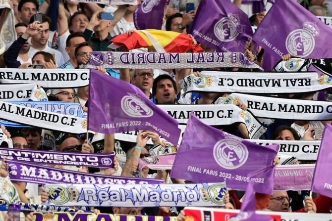 Aficionados del Real Madrid sostienen sus bufandas y ondean banderas antes del partido de fútbol de la final de la UEFA Champions League.