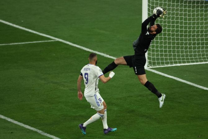 El portero brasileño del Liverpool, Alisson Becker (R), hace una salvada ante el delantero francés del Real Madrid, Karim Benzema.