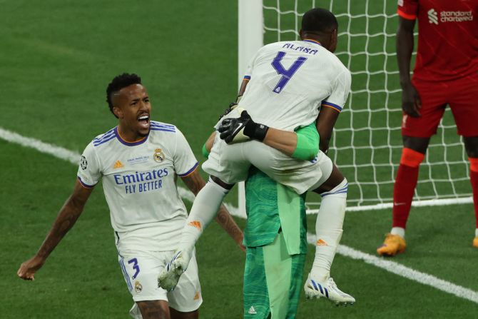 El portero belga del Real Madrid, Thibaut Courtois, celebra una salvada con el defensor austriaco del Real Madrid, David Alaba (R), y el defensor brasileño del Real Madrid, Eder Militao.