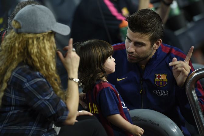 Piqué, Shakira y su hijo Milan conversan antes del partido de fútbol de la liga española FC Barcelona vs Eibar en el estadio Camp Nou de Barcelona el 18 de octubre de 2014.