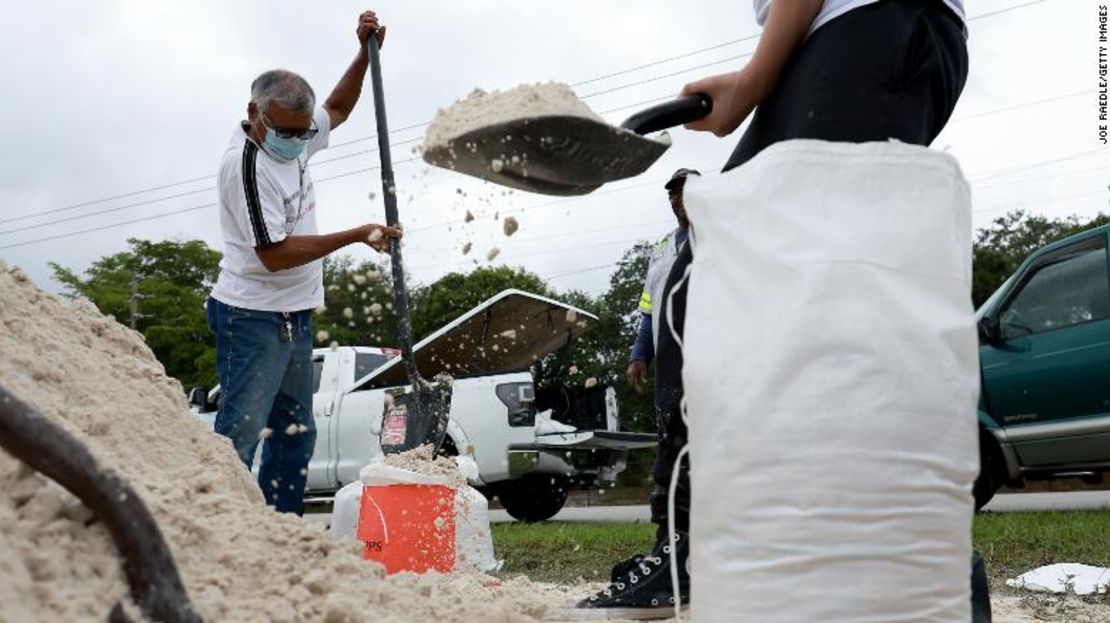 Las personas llenan sacos de arena mientras preparan sus hogares para la esperada llegada de una tormenta tropical el viernes en Pembroke Pines, Florida.