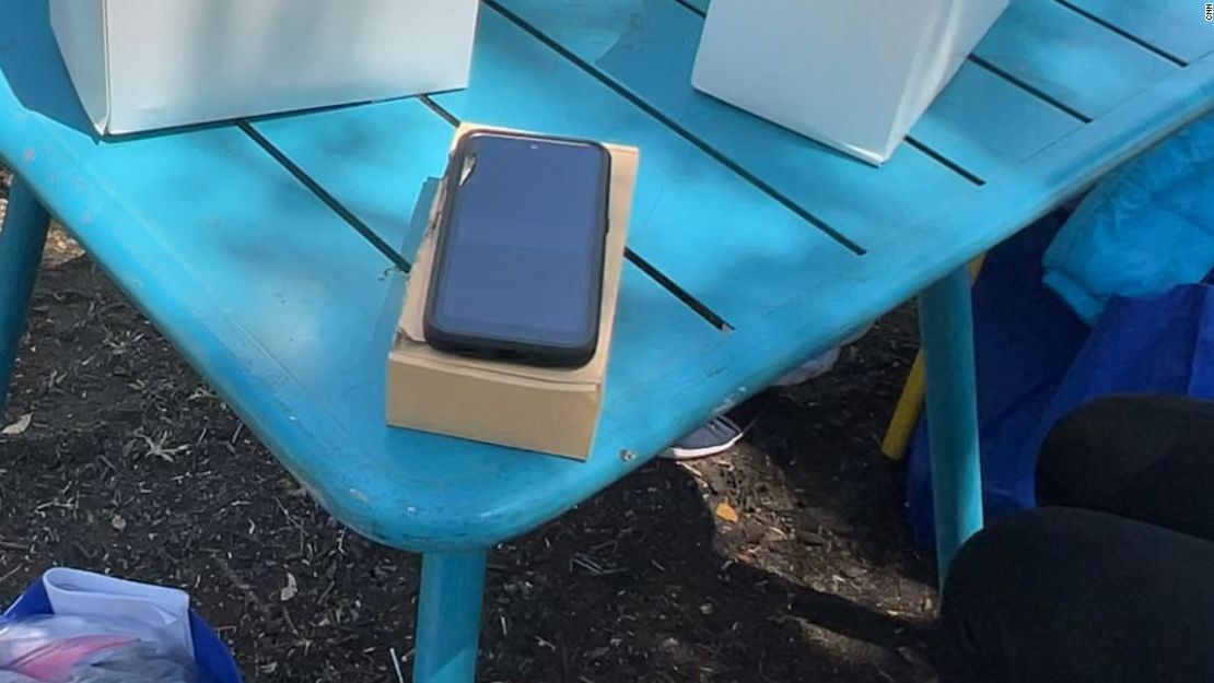 Un teléfono celular proporcionado por el gobierno se encuentra sobre una mesa en un parque donde los migrantes recientemente liberados se han estado reuniendo en San Antonio, Texas.