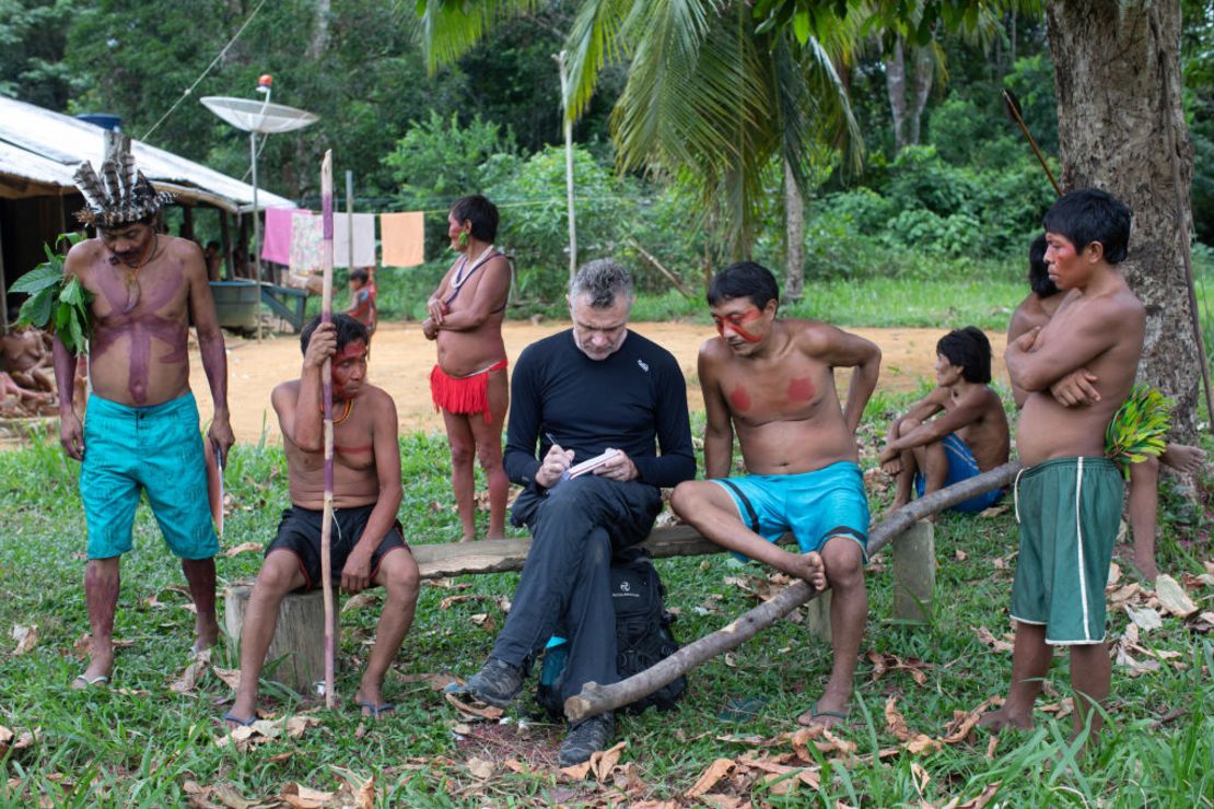 El veterano corresponsal extranjero Dom Phillips (C) toma notas mientras habla con indígenas en la Aldeia Maloca Papiú, en el estado de Roraima, Brasil, el 15 de noviembre de 2019.