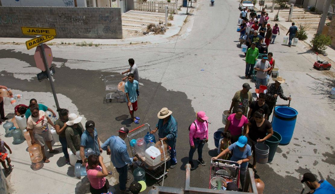 Los residentes hacen cola para recoger agua limpia de un camión cisterna en el municipio de García, al noroeste del área metropolitana de Monterrey, estado de Nuevo León, México, el 8 de junio de 2022.