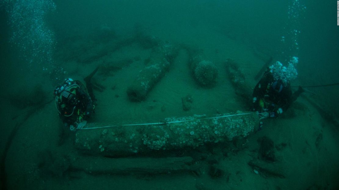 Los hermanos Lincoln Barnwell (izquierda) y Julian Barnwell miden un cañón del naufragio del HMS Gloucester.