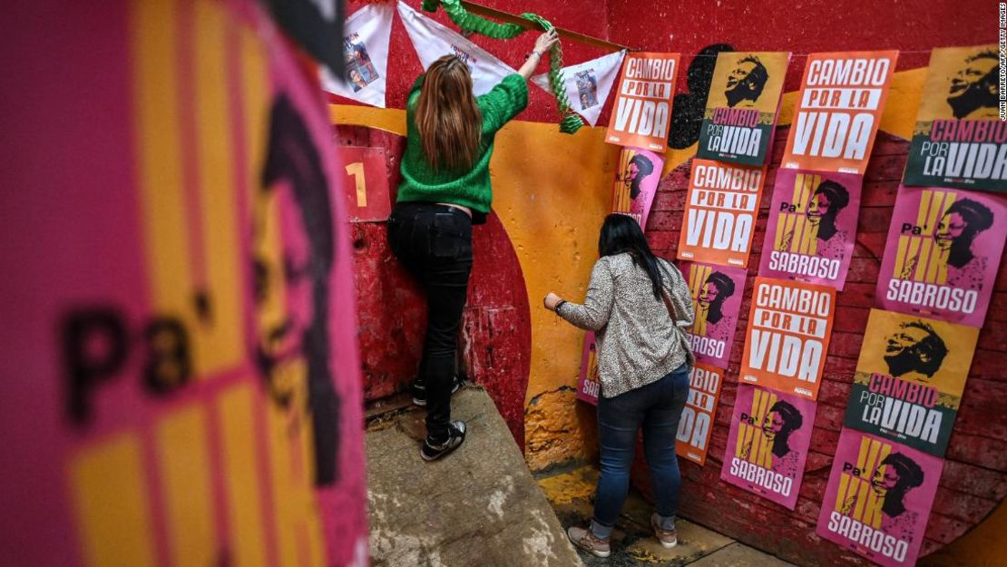 Simpatizantes del candidato presidencial de izquierda colombiano Gustavo Petro pegan pancartas antes de una manifestación en el barrio de Fontibón en Bogotá el 12 de junio de 2022.