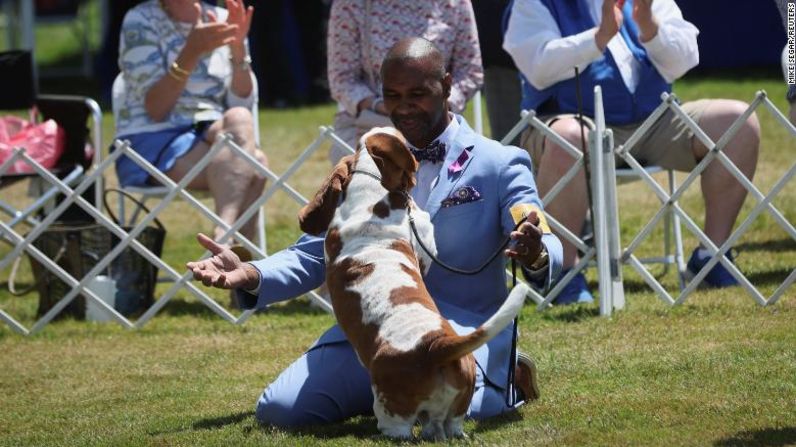 El adiestrador Claudio Cruz abraza a Ethan, un basset hound, tras ganar el concurso "Mejor de la Raza" el lunes.