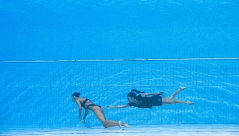 FOTOS | Deportistas que tuvieron emergencias médicas mientras competían. | "Creo que nunca antes había nadado tan rápido, incluso cuando obtuve medallas olímpicas", contó a una emisora de radio española la entrenadora Andrea Fuentes, quién saltó a la piscina tras ver a Álvarez hundirse hasta el fondo. La nadadora artística de 25 años se desmayó al final de su rutina en el evento libre femenino en solitario. Fuentes y el socorrista la sacaron a la superficie y la llevaron al borde de la piscina donde recibió atención médica. (OLI SCARFF/AFP via Getty Images) →