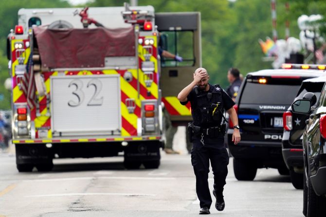 Un agente de policía reacciona mientras camina en el centro de Highland Park, Illinois, después del tiroteo del 4 de julio.