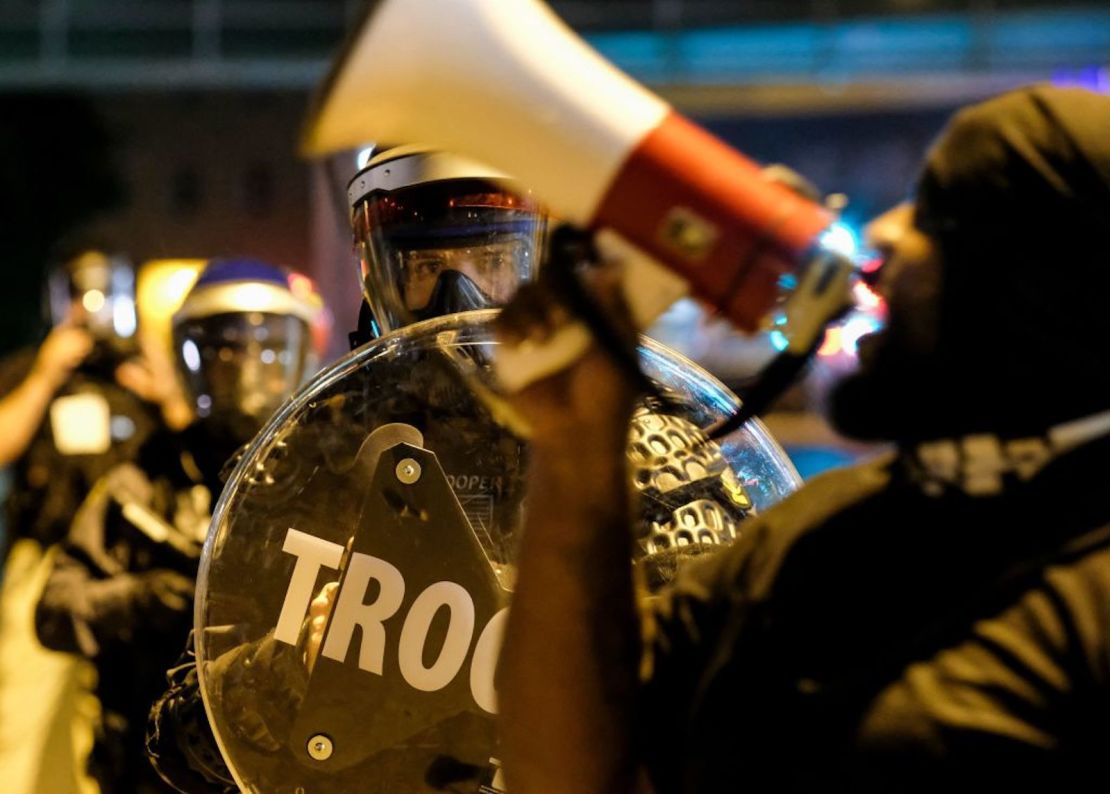 Soldados con equipo antidisturbios observan cómo los manifestantes se reúnen frente al ayuntamiento de Akron para protestar por el asesinato de Jayland Walker, baleado por la policía, en Akron, Ohio, el 3 de julio de 2022.