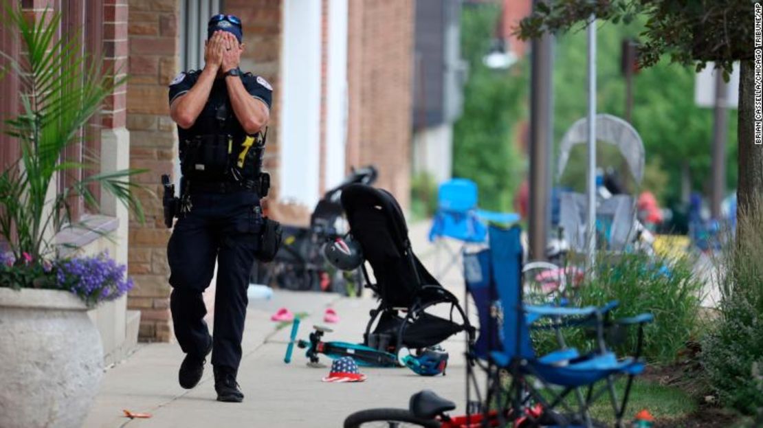 A Lake County police officer walks down Central Ave in Highland Park on Monday.