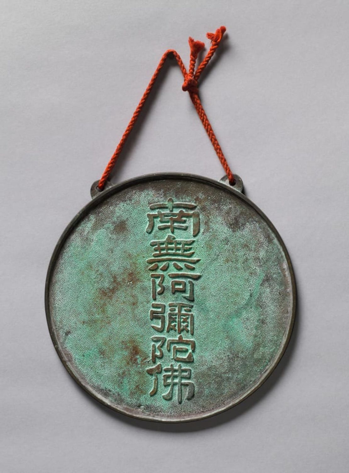 Una segunda placa de bronce, que está marcada en la parte posterior con el nombre de Buda Amitabha, que se cree fue soldado, oculta la imagen del Buda.