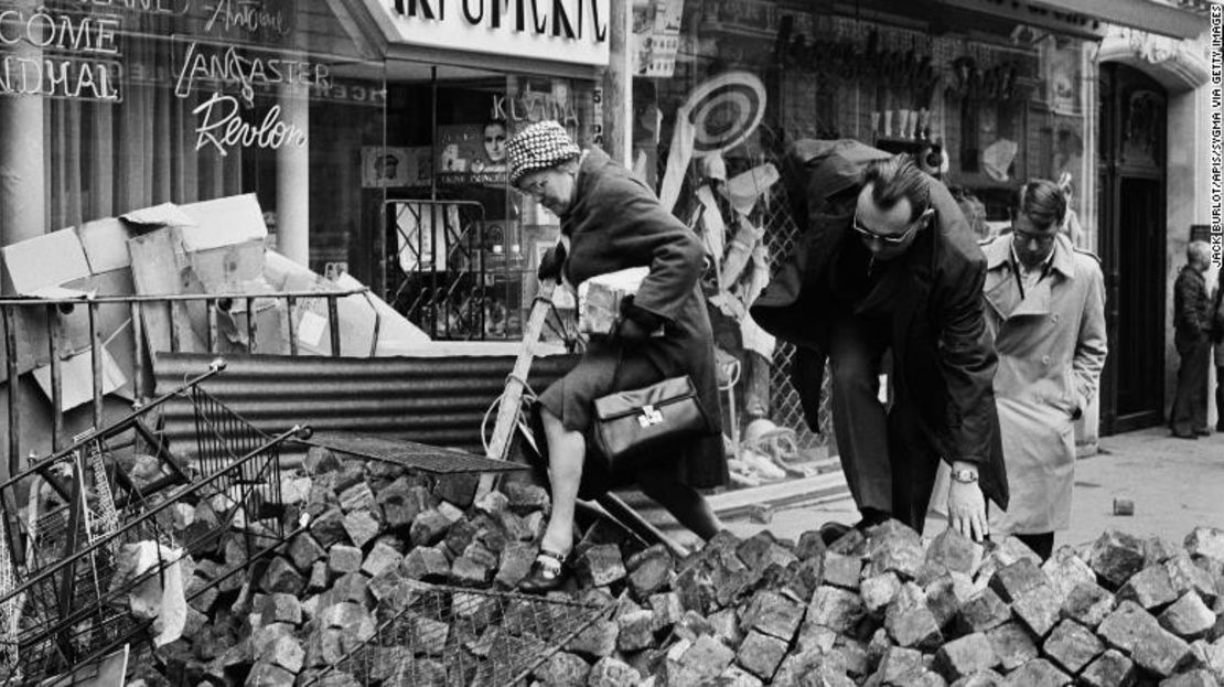 Habitantes de París trepan sobre montones de adoquines en las calles durante las manifestaciones estudiantiles francesas de mayo de 1968.