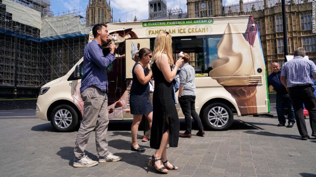 Un grupo de personas come un helado frente a la sede del Parlamento, en Londres, el miércoles 13 de julio de 2022. La Oficina Meteorológica ha emitido un aviso meteorológico ámbar por calor extremo en algunas zonas del Reino Unido ante la posibilidad de que sigan subiendo las temperaturas esta semana (AP Photo/Alberto Pezzali).