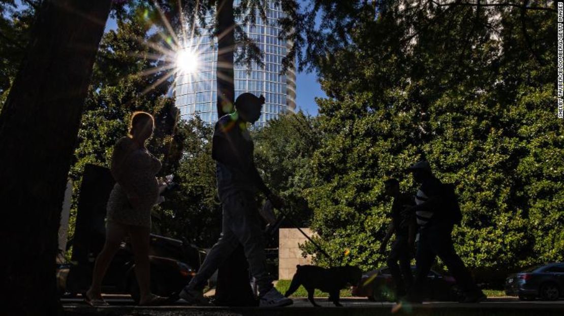 Unos peatones caminan por una calle durante una ola de calor en Dallas, Texas.