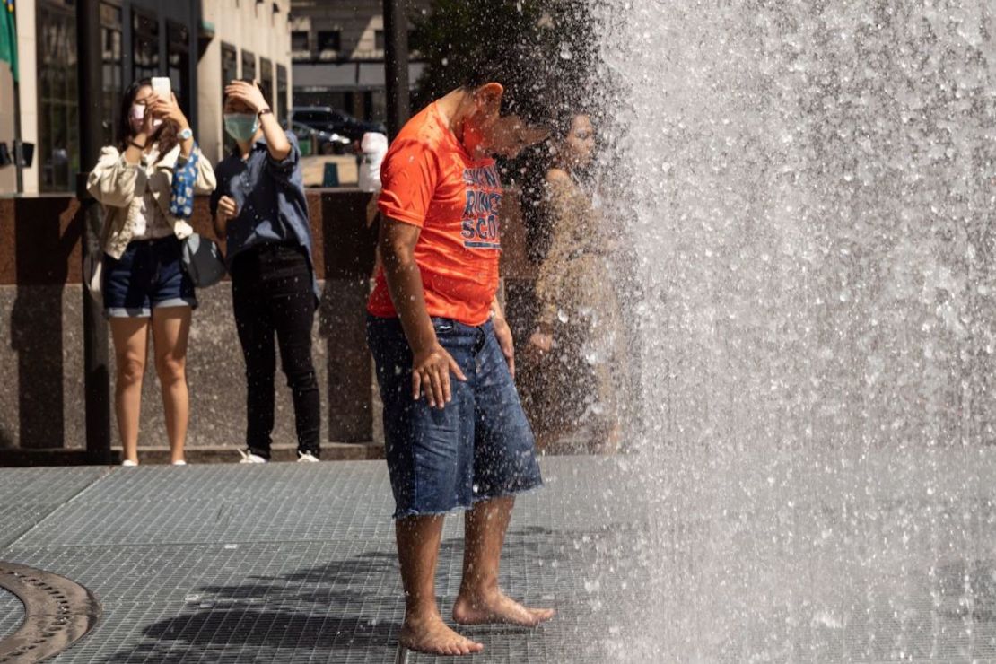 La gente juega en la escultura a base de agua del artista Jeppe Hein titulada "Changing Spaces" en el Rockefeller Center Plaza en la ciudad de Nueva York el 19 de julio de 2022, mientras la ola de calor continúa en Europa y América del Norte.