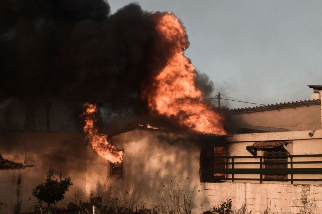 Una casa arde mientras continúan los incendios forestales al pie del monte Penteli, los suburbios de la ladera al norte de Atenas, lo que obligó a las personas a evacuar sus hogares el 20 de julio de 2022.