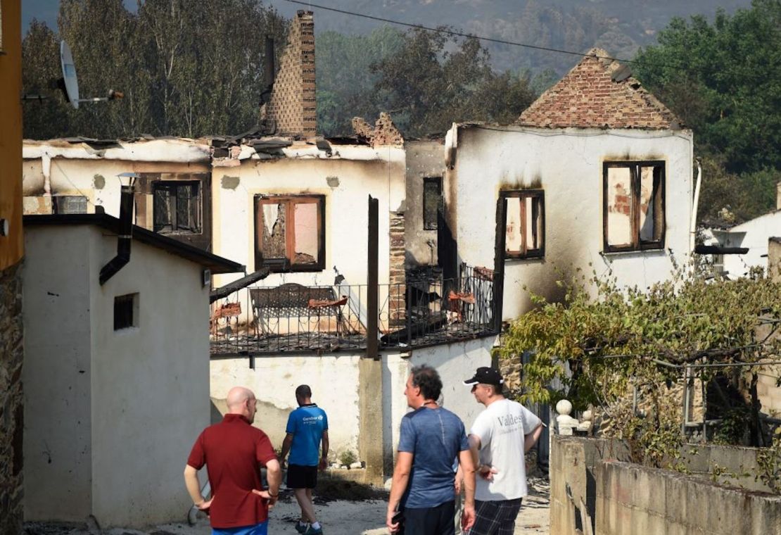 Los aldeanos miran las casas quemadas después de un incendio forestal en A Veiga de Cascalla, cerca de O Barco de Valdeorras, en el norte de España el 19 de julio de 2022.