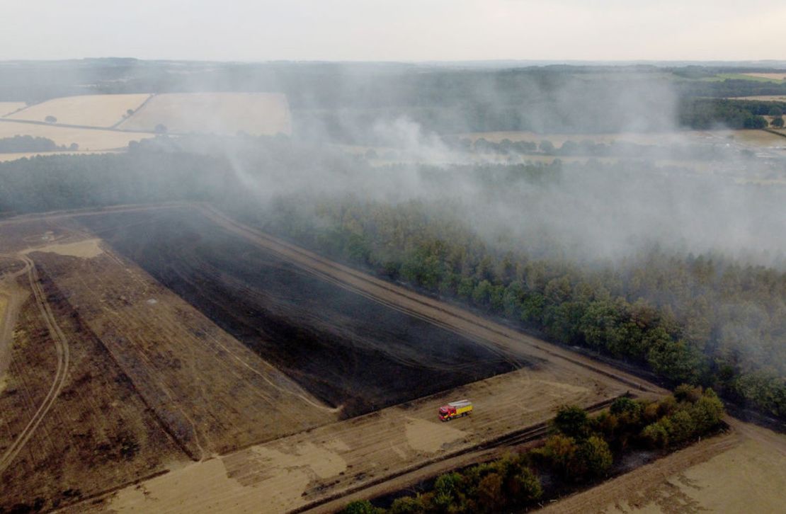 En esta vista aérea, se ve un camión de bomberos en el campo mientras el humo se eleva de los árboles el 19 de julio de 2022 en Blidworth, Inglaterra. Una serie de incendios forestales han estallado en Inglaterra cuando la ola de calor del Reino Unido alcanzó temperaturas récord de 40,3 °C.