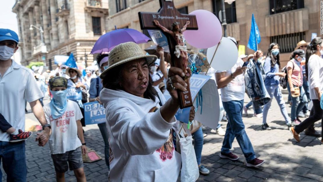 Una mujer sostiene una cruz mientras participa en una marcha contra el aborto en la Ciudad de México en mayo.