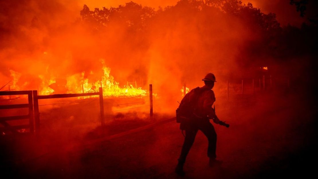 Un bombero corre para extinguir las llamas del Oak Fire en el condado de Mariposa el viernes.