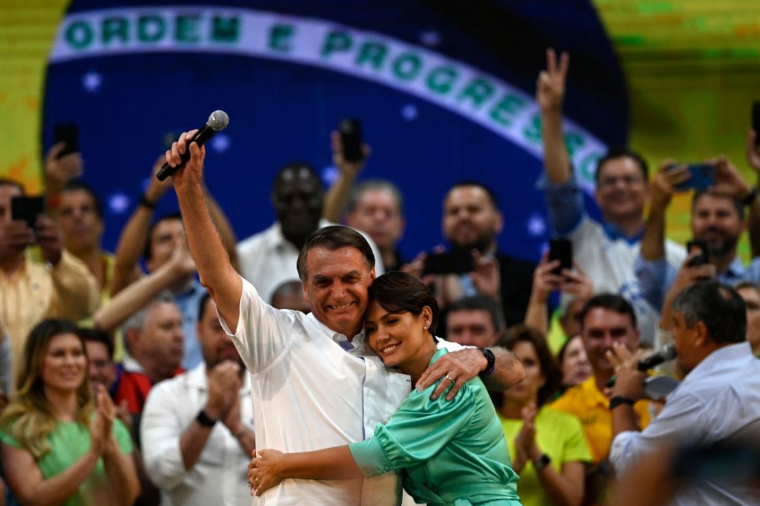 El presidente de Brasil, Jair Bolsonaro (izq.), abraza a su esposa Michelle Bolsonaro durante la convención nacional del Partido Liberal, donde fue designado oficialmente candidato a la reelección, en el gimnasio Maracanazinho de Río de Janeiro, Brasil, el 24 de julio de 2022.