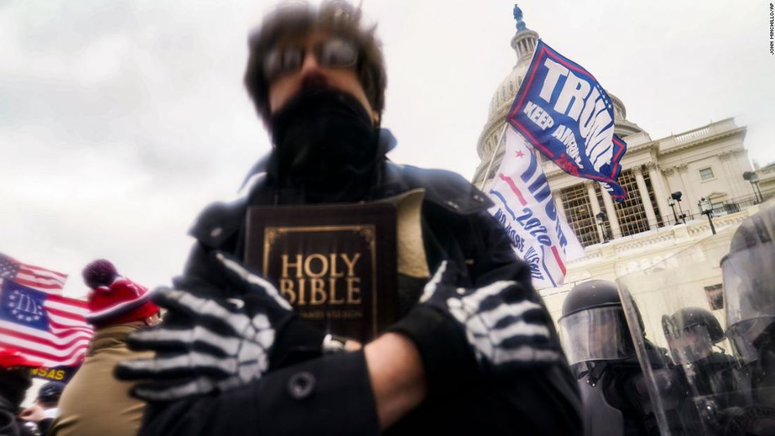 Un seguidor de Trump sostiene una Biblia mientras se reúne con otras personas frente al Capitolio de EE.UU. el 6 de enero de 2021.