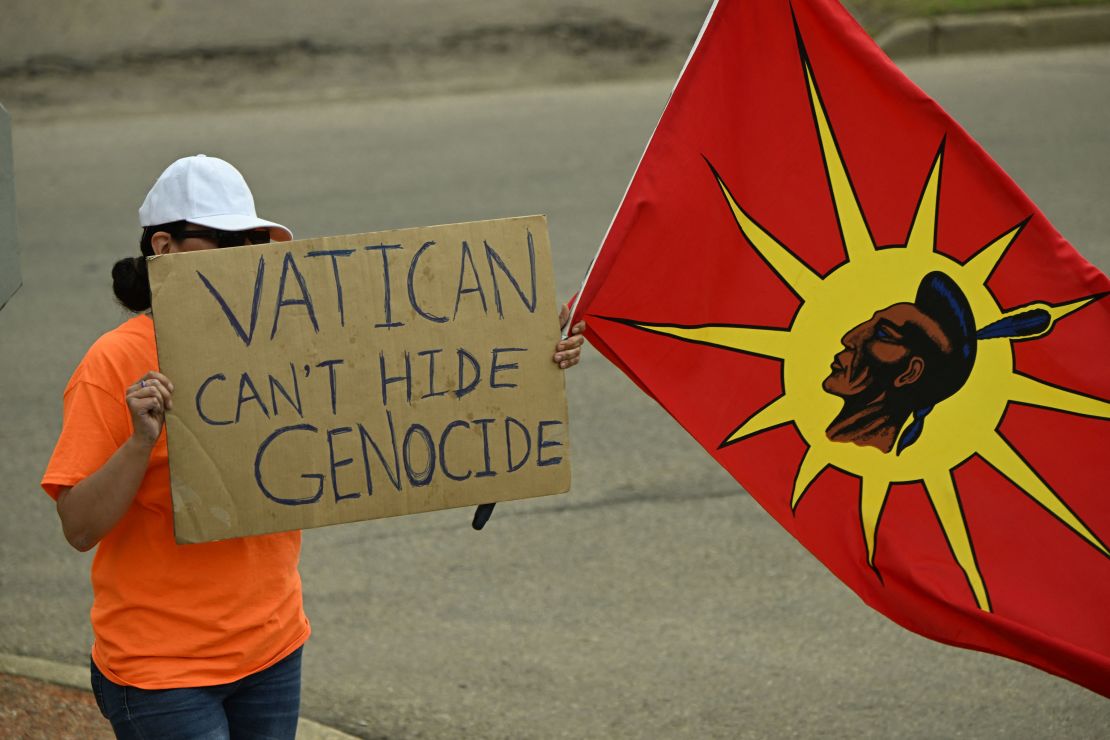 Un manifestante sostiene un cartel que dice "El Vaticano no puede ocultar el genocidio" durante la llegada del papa Francisco a Canadá el 24 de julio.