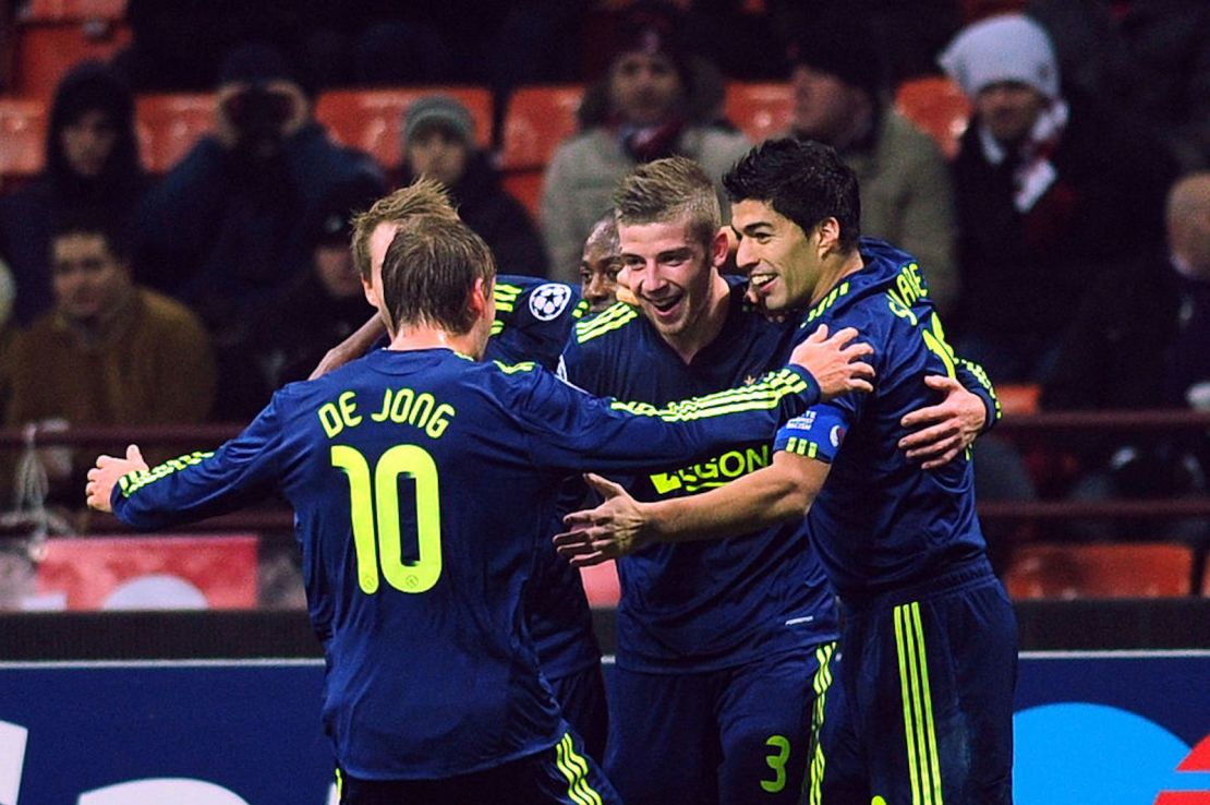 El defensa belga del Ajax Amsterdam, Toby Alderweireld (en el centro), celebra después de anotar con el delantero de Uruguay Luis Suárez (a la derecha) y el mediocampista danés Christian Eriksen, un gol contra el AC Milán el 8 de diciembre de 2010 en el estadio San Siro en Milán.