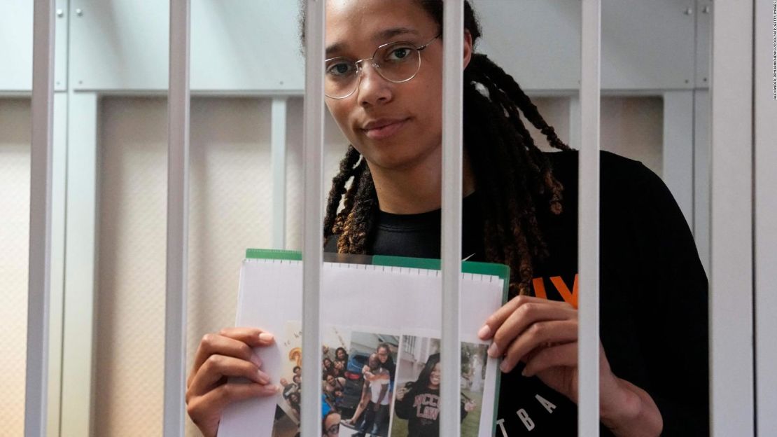 Brittney Griner sostiene fotografías mientras permanece tras las rejas del área de los acusados ​​antes de una audiencia ante una corte, en las afueras de Moscú, este miércoles.