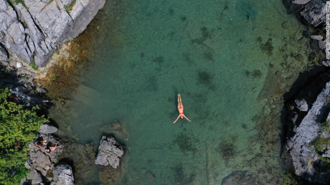 Una mujer nada para refrescarse en el lago Xhemas, un pequeño lago natural situado en el Parque Nacional de Valbona, cerca de Dragobi, el 4 de agosto de 2021.