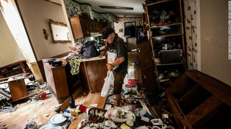 Kermit Clemons recoge artículos personales y medicamentos de la casa de su exsuegra el jueves. La inundación arrastró la casa rodante de sus cimientos y la arrastró unos 76 metros de su ubicación original.