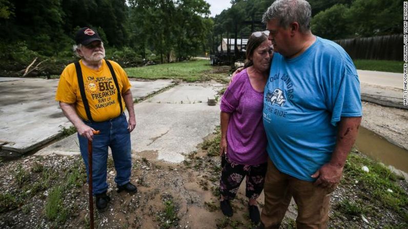 El pastor Pete Youmans consuela a Debby Miniard mientras su padre, Charles Blankenship, se para cerca de donde solía estar su garaje en el condado de Perry. Blankenship lo perdió todo, incluida su casa rodante.