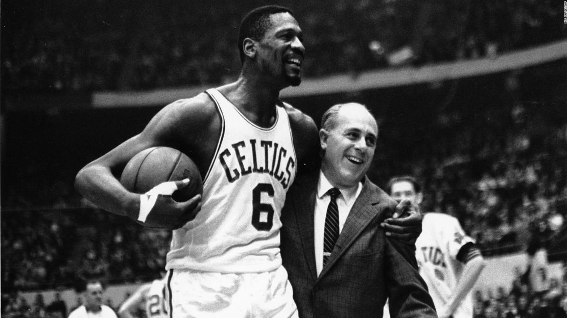 Russell es  felicitado por el legendario entrenador de los Celtics, Arnold "Red" Auerbach, después de anotar el punto número 10.000 de su carrera en un partido contra los Baltimore Bullets en Boston Garden el 12 de diciembre de 1964.