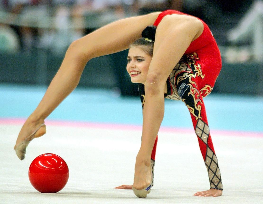 La campeona Alina Kabaeva de Rusia posa con el balón durante la final de la competición individual del Campeonato Mundial de Gimnasia Rítmica en Osaka el 2 de octubre de 1999. Kabaeva anotó 10.00 puntos en el evento del balón para llevarse la medalla de oro.