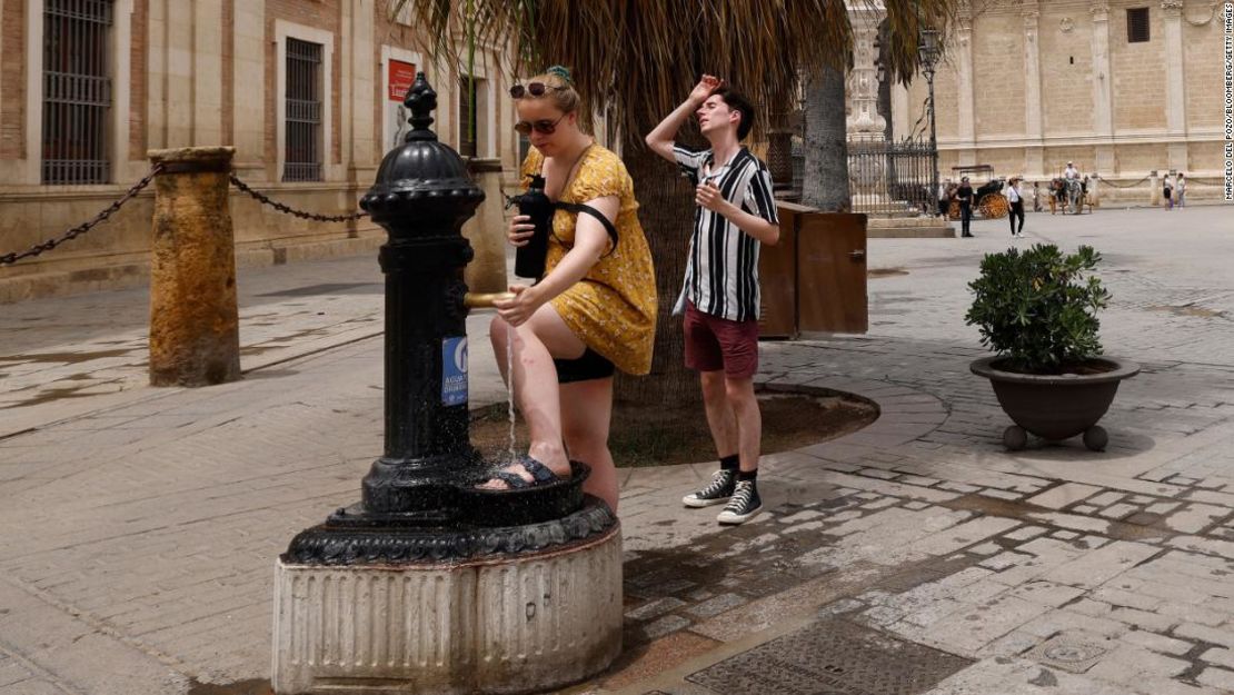 Los visitantes utilizan una fuente pública en Sevilla, España.