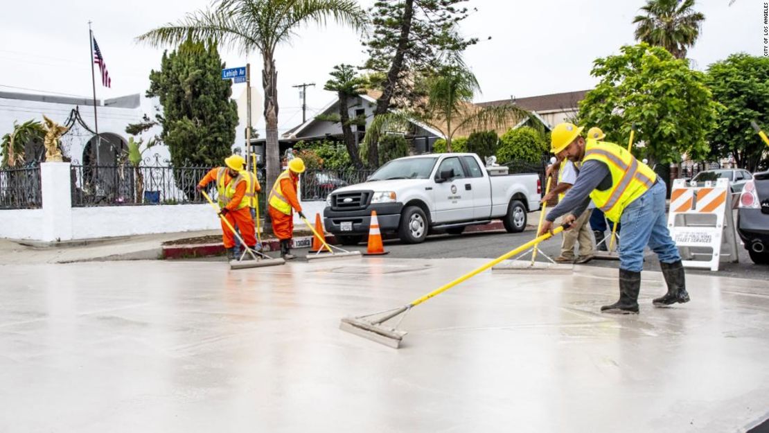 Trabajadores pintando una carretera en Los Ángeles para hacer frente al calor.