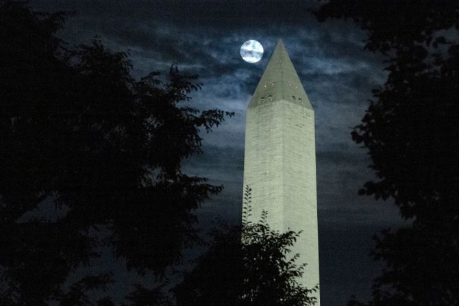 La luna se oculta entre las nubes cuando pasa detrás del Monumento a Washington el 11 de agosto de 2022 en Washington, Estados Unidos.