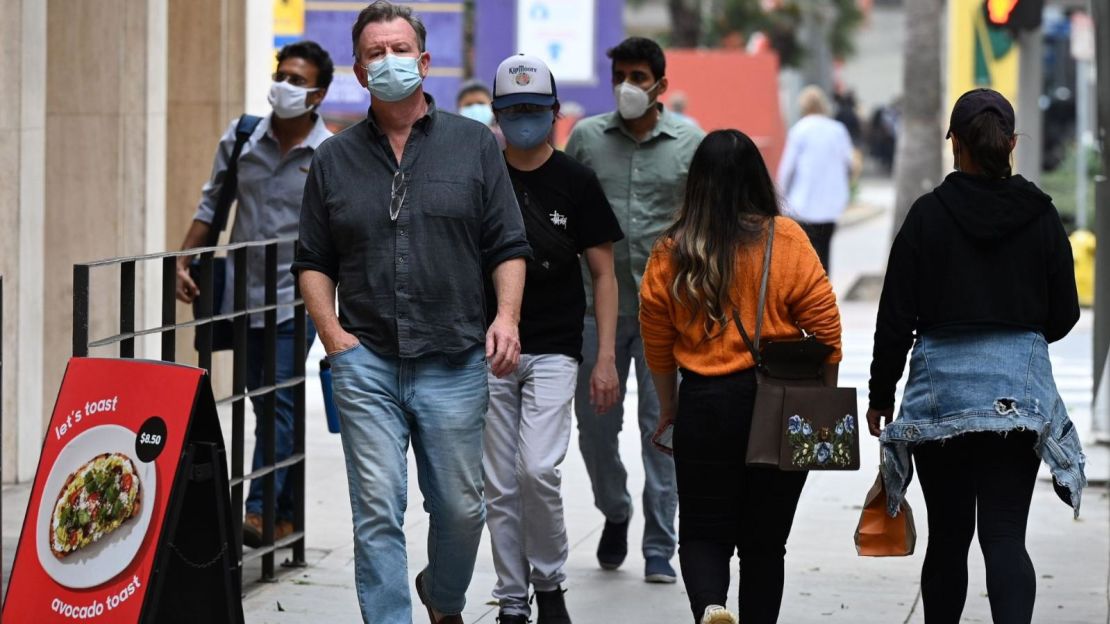 Estadounidenses caminan por las calles con máscaras faciales para evitar contagios de covid-19, en una fotografía de archivo