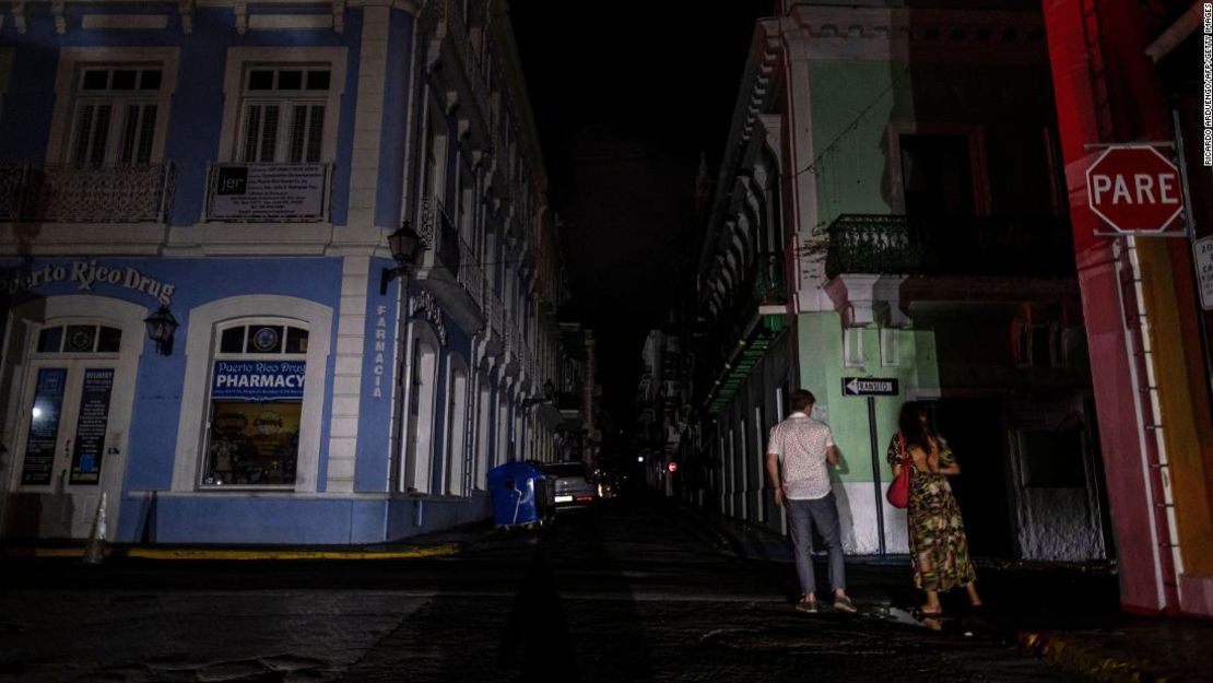 Una pareja camina por una calle oscura en San Juan después del apagón del 6 de abril.