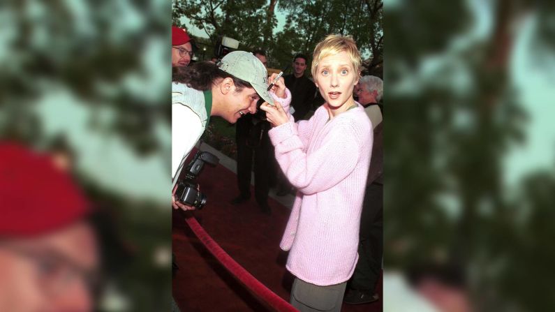 Heche firma la gorra de un fanático en el estreno de "Get Real" en 1999.