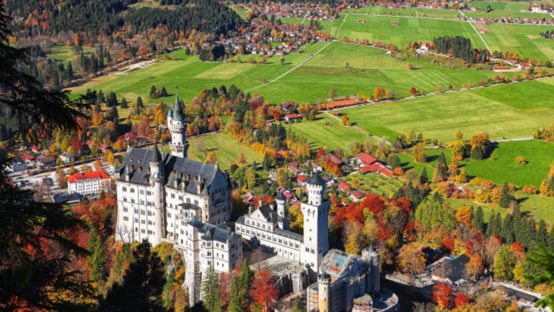 Una vista aérea del famoso castillo de Neuschwanstein rodeado de la gloria otoñal bávara.Crédito: pilat666/Adobe Stock