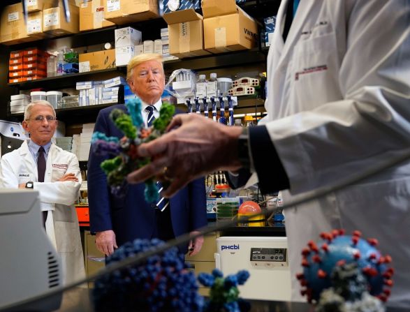 Fauci y el entonces presidente de Estados Unidos, Donald Trump, miran modelos de coronavirus durante una gira por los Institutos Nacionales de Salud en marzo de 2020.