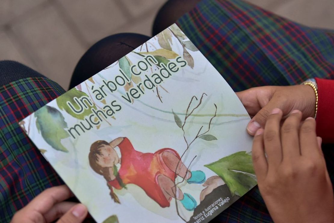 Niños con el libro "Un árbol con muchas verdades", un cuento infantil para socializar el informe de la Comisión de la Verdad, en un colegio público de Bogotá